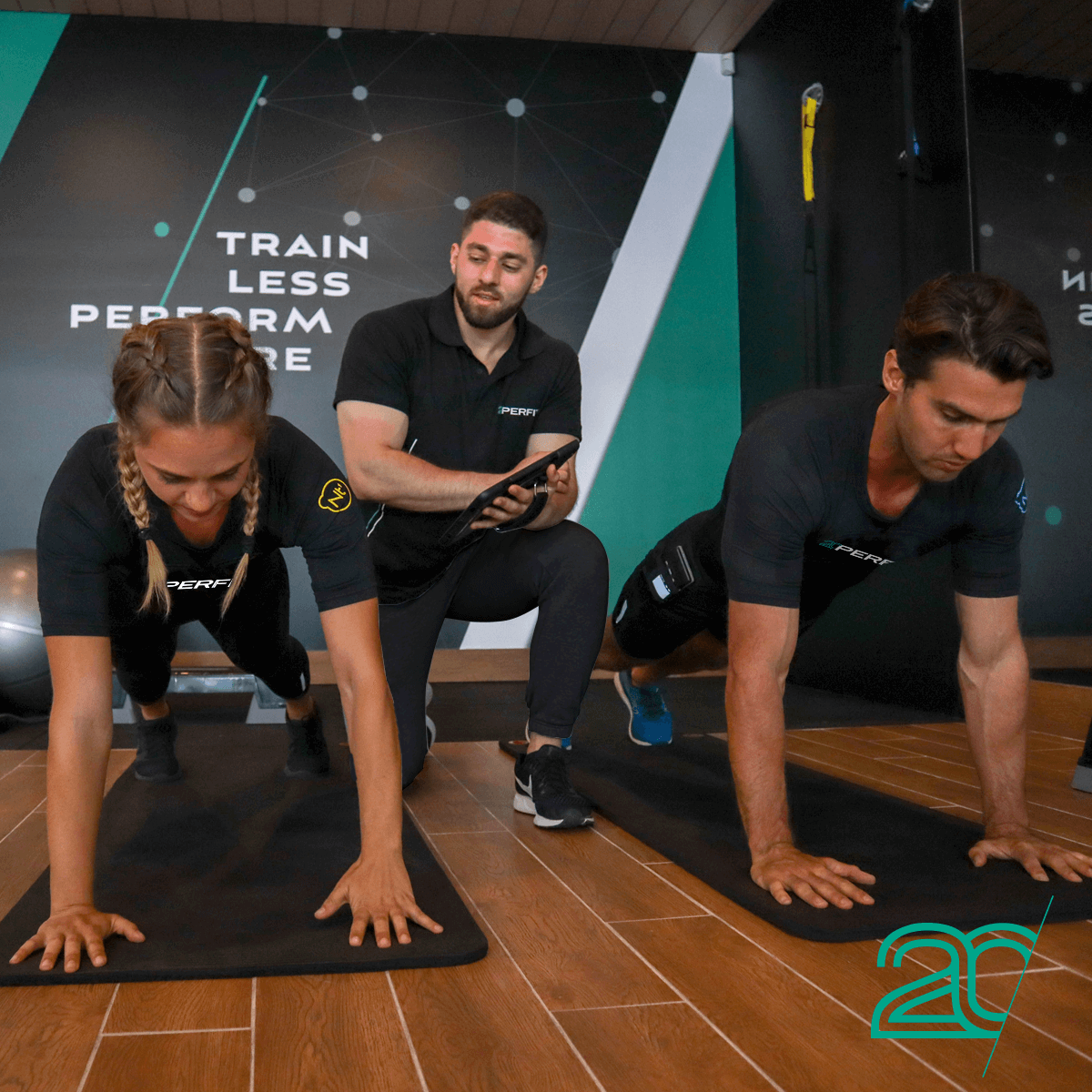 Two Persons Doing Core Exercises with 20PerFit's EMS Technology