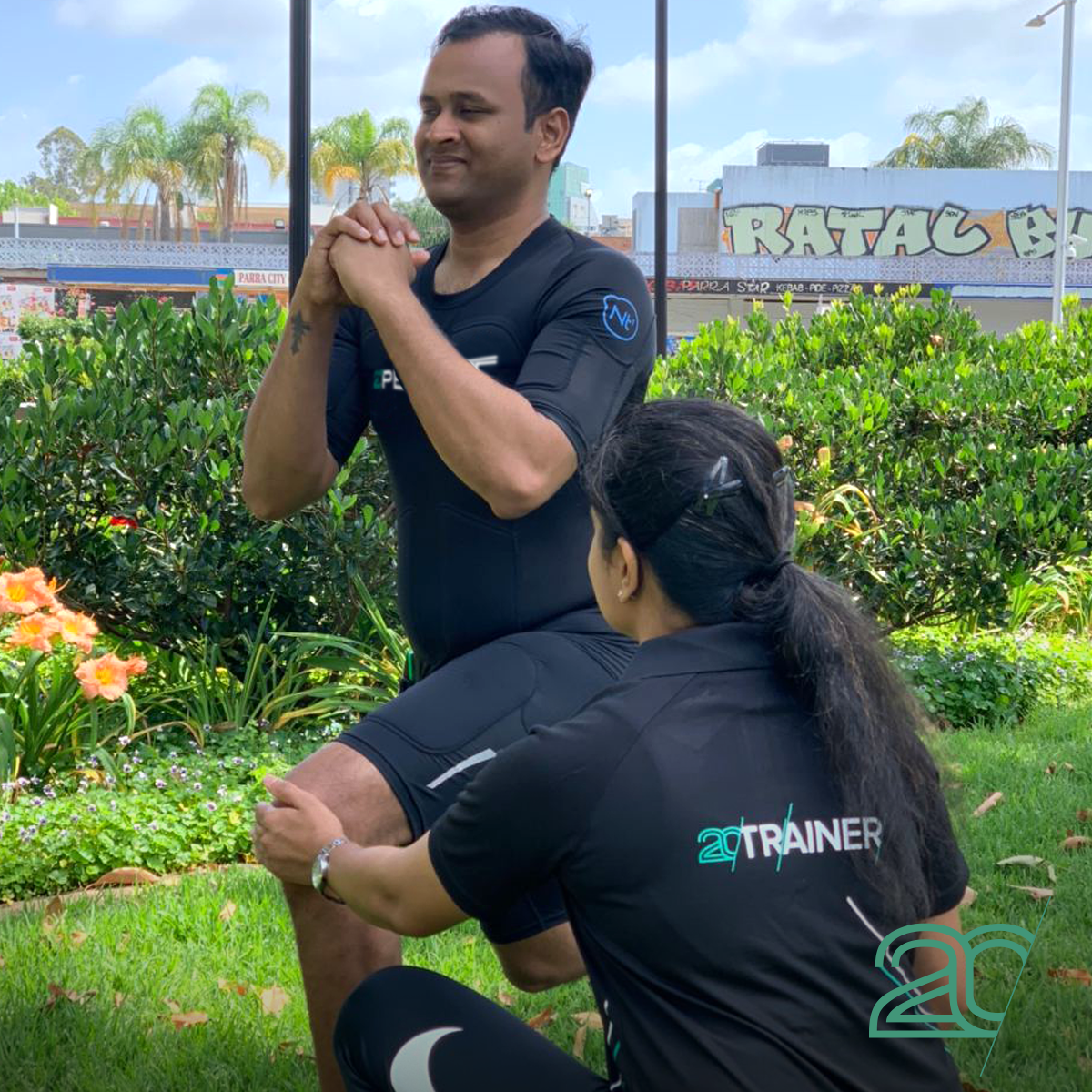 Man Exercising Split Squats with a Personal trainer using 20PerFit's Mobile EMS technology